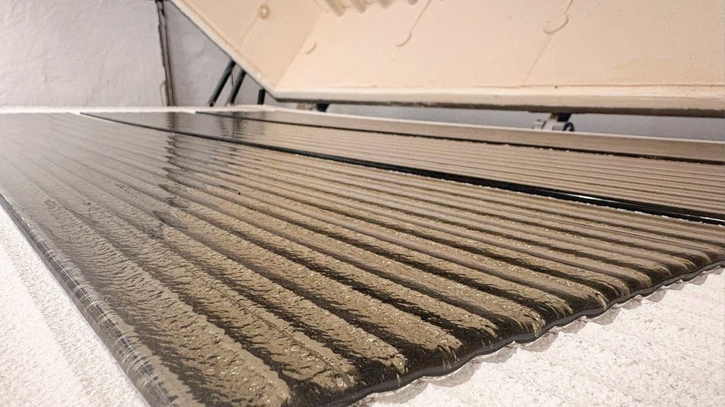 Bronze tinted kiln-formed reeded glass inside a specialist kiln at Royston Glass, showing the handcrafted linear texture created through the glass slumping process over custom moulds.