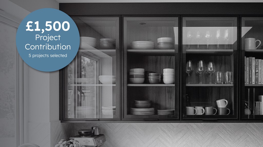 Modern kitchen featuring black aluminium framed glass cabinet doors with a £1,500 project contribution competition graphic promoting five selected interior projects by The Framed Door Co.