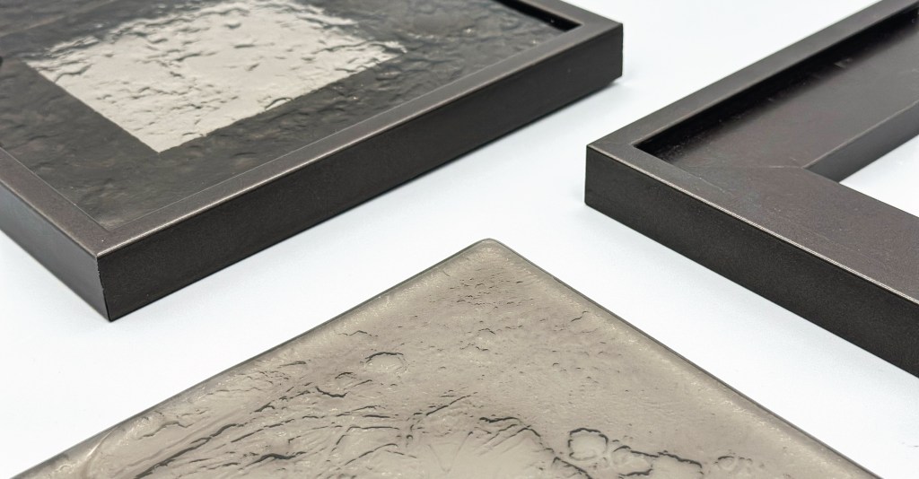 Three textured picture frames with a glossy finish, arranged on a light surface.